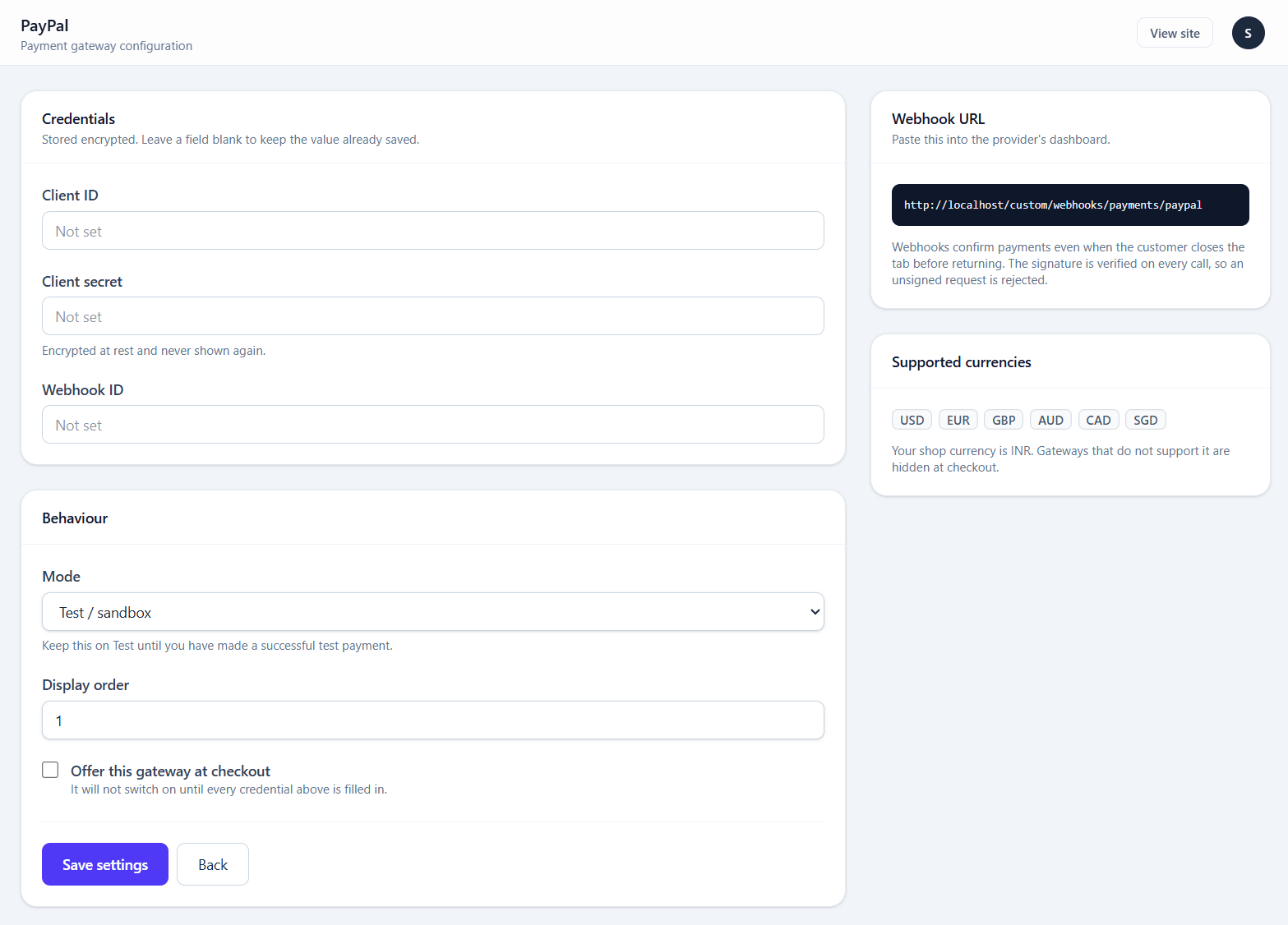 A gateway's credential screen, with its test and live keys, mode switch, and the webhook URL to copy